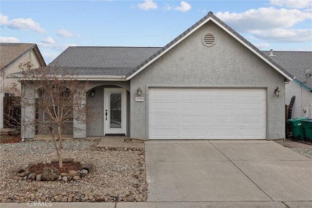 single story home with stucco siding, an attached garage, and concrete driveway