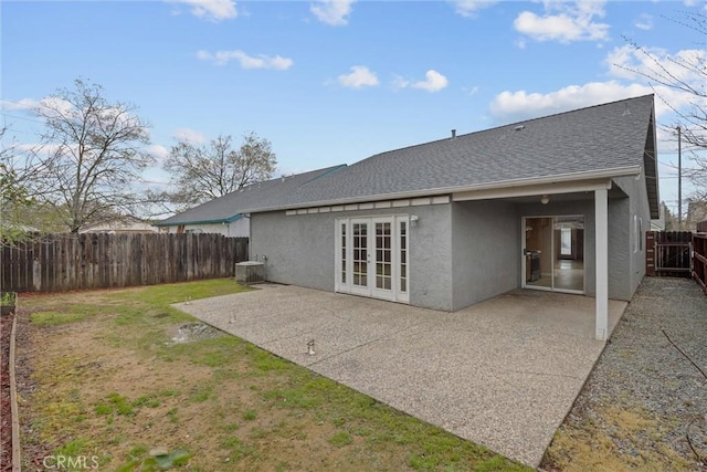 rear view of property featuring central air condition unit, stucco siding, a patio, a fenced backyard, and french doors