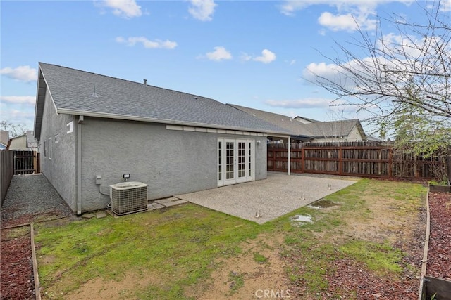 rear view of property featuring stucco siding, cooling unit, french doors, a fenced backyard, and a patio