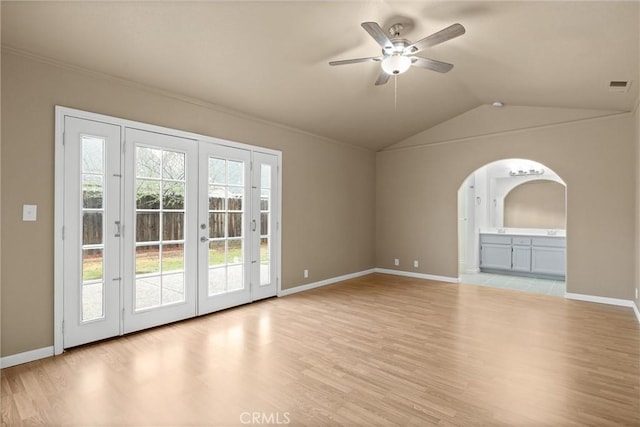 unfurnished living room featuring visible vents, light wood finished floors, arched walkways, ceiling fan, and vaulted ceiling