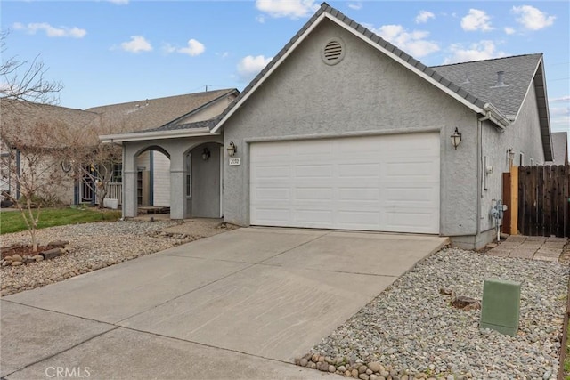 single story home featuring fence, driveway, covered porch, stucco siding, and a garage