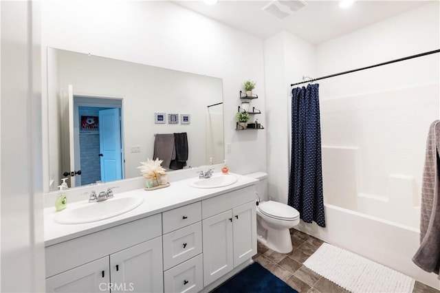 full bathroom featuring double vanity, toilet, visible vents, and a sink