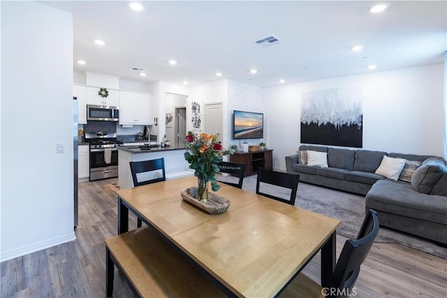 dining room featuring visible vents, recessed lighting, and wood finished floors