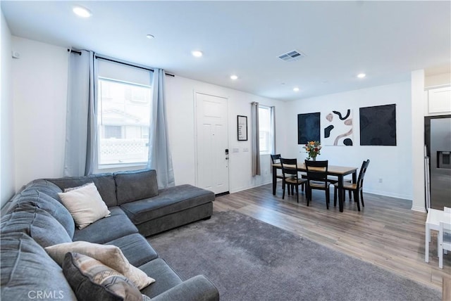 living room with plenty of natural light, recessed lighting, visible vents, and light wood-style floors