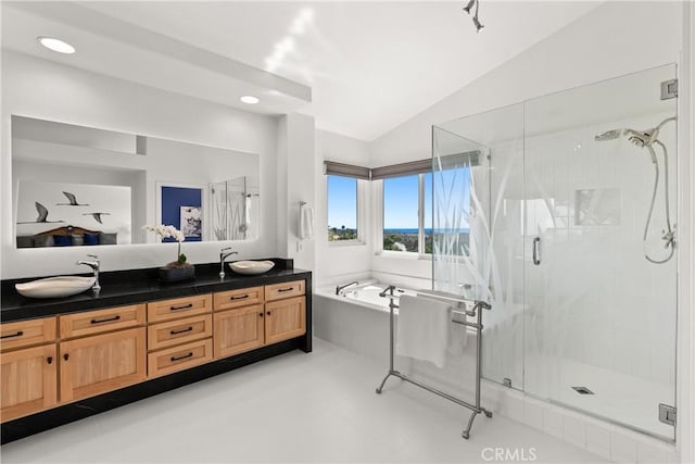 full bathroom with vaulted ceiling, a bath, a stall shower, and a sink