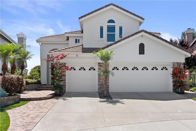 view of front of property with a garage, brick siding, concrete driveway, and a tile roof