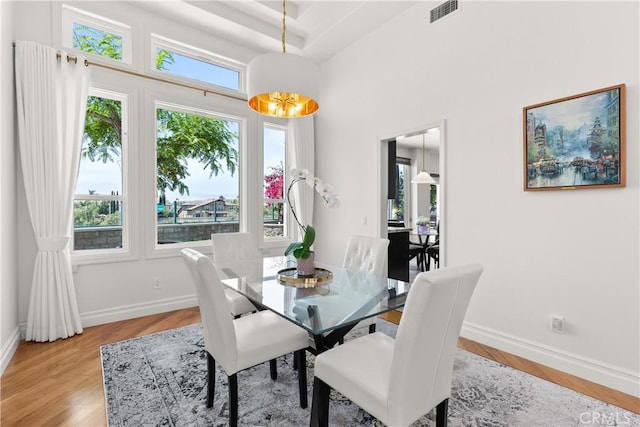 dining space with a wealth of natural light, visible vents, light wood finished floors, and baseboards