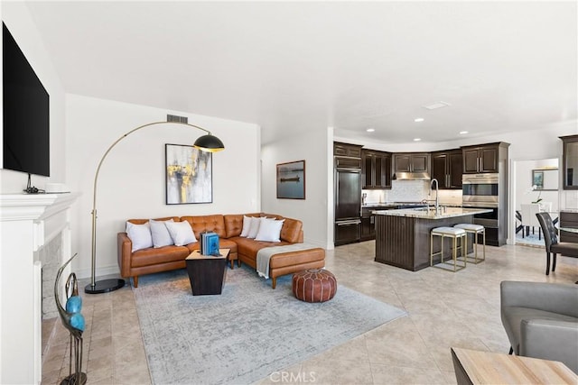 living room with visible vents, baseboards, light tile patterned floors, recessed lighting, and a fireplace