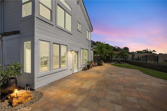 property exterior at dusk with a patio area