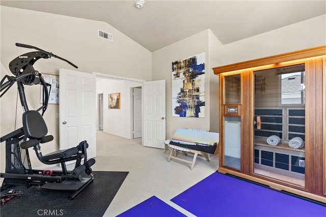 exercise area with visible vents, carpet flooring, and vaulted ceiling