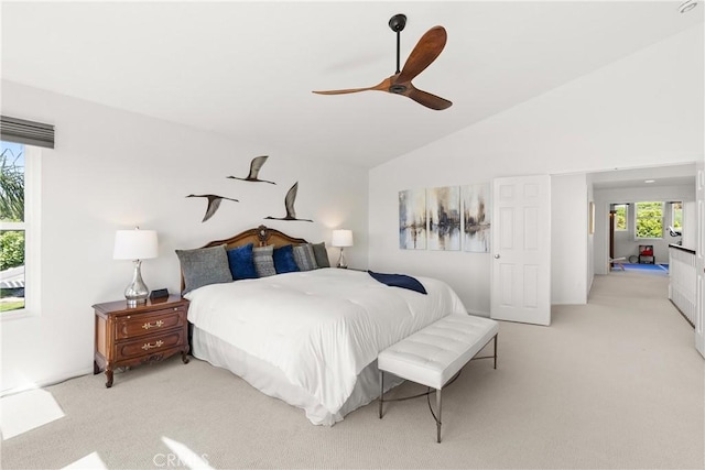 bedroom featuring light colored carpet, lofted ceiling, and multiple windows