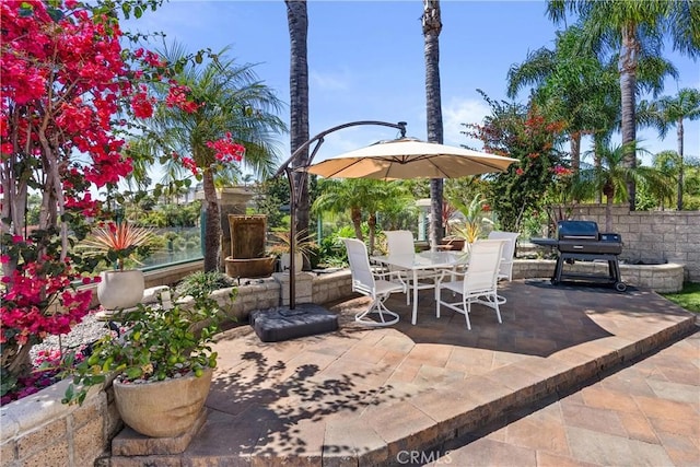 view of patio featuring outdoor dining area, grilling area, and fence