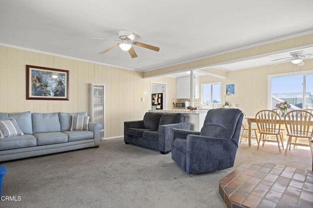 carpeted living room featuring a ceiling fan and ornamental molding