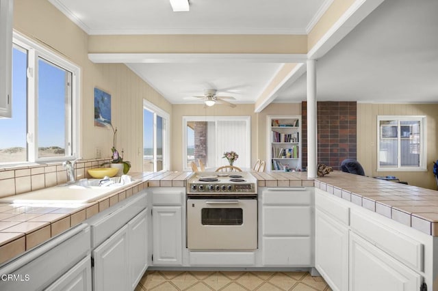 kitchen featuring a peninsula, tile countertops, white cabinets, and white electric stove