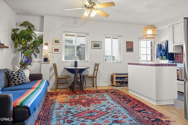 dining room featuring ceiling fan, baseboards, and light wood-style flooring