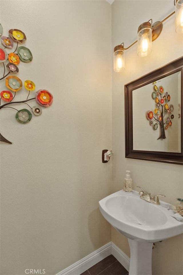 bathroom with a sink and baseboards