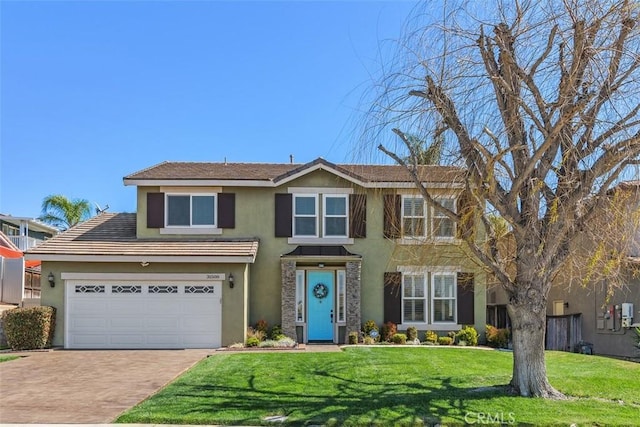 view of front facade with a front lawn, decorative driveway, a garage, and stucco siding