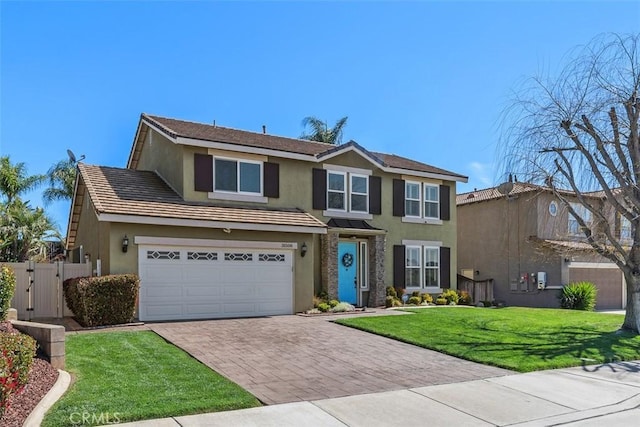 traditional-style home featuring stucco siding, a front lawn, a gate, decorative driveway, and fence