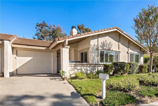 view of front of house with concrete driveway, an attached garage, a chimney, and stucco siding