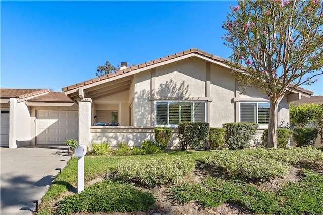 view of front of property featuring stucco siding, concrete driveway, and a garage