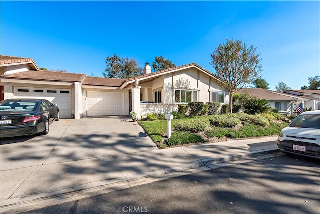 view of front of property featuring concrete driveway, a garage, and stucco siding