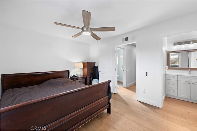 bedroom featuring visible vents, light wood-style flooring, baseboards, and a sink