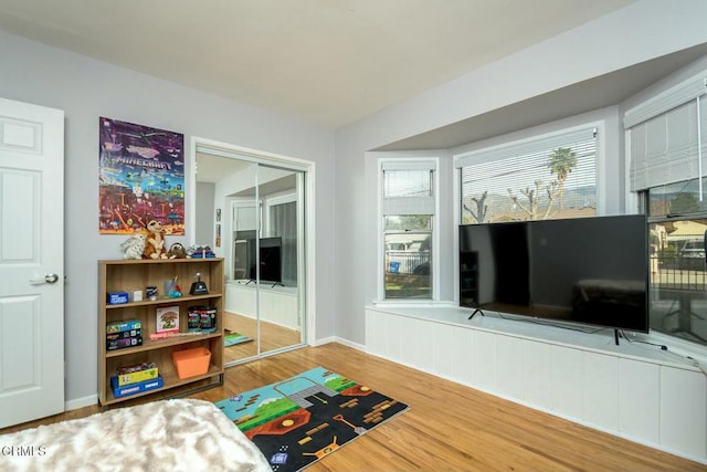 bedroom featuring wood finished floors, a closet, and baseboards