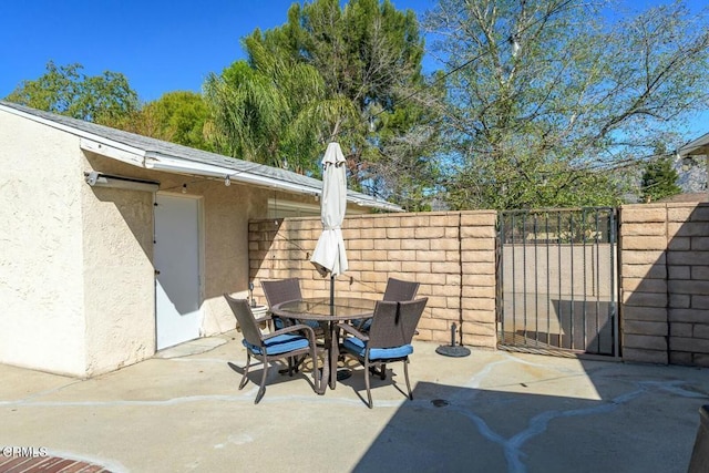 view of patio with outdoor dining area and fence