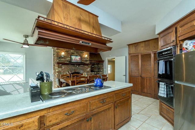 kitchen featuring light tile patterned floors, brown cabinets, and appliances with stainless steel finishes