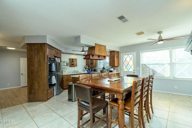 dining space featuring visible vents, baseboards, ceiling fan, and light tile patterned flooring