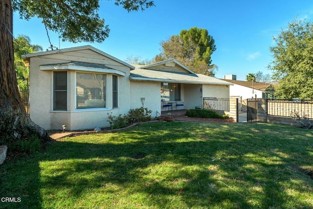 bungalow-style home featuring a gate, stucco siding, a front yard, and fence