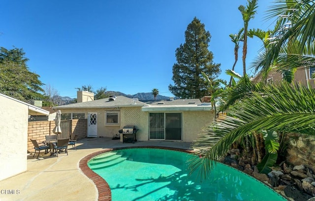 view of swimming pool featuring area for grilling, a patio, and fence