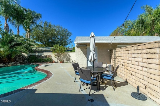 view of patio with outdoor dining space, a fenced backyard, and a fenced in pool