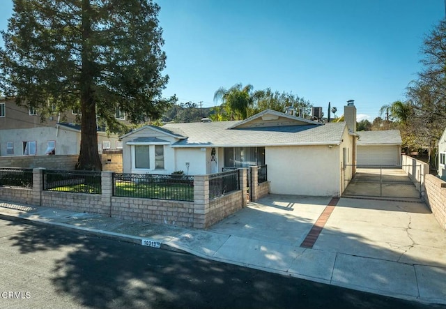 ranch-style house with a fenced front yard, stucco siding, and a detached garage