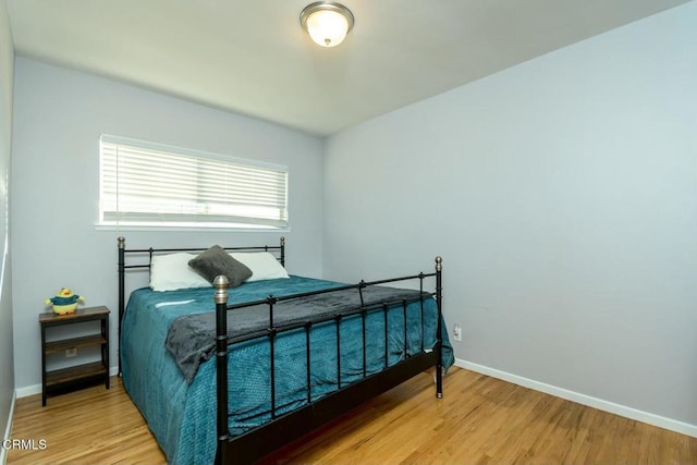 bedroom featuring baseboards and wood finished floors