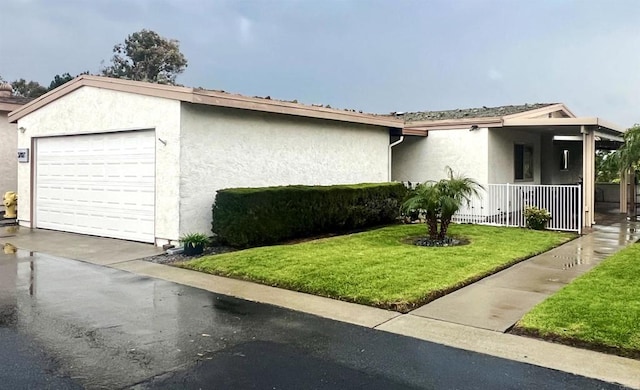 ranch-style home featuring a front yard, stucco siding, covered porch, a garage, and driveway