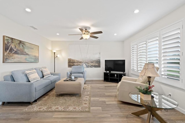 living room featuring light wood-type flooring, visible vents, a ceiling fan, recessed lighting, and baseboards