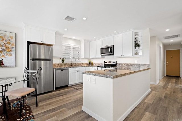kitchen with visible vents, appliances with stainless steel finishes, white cabinetry, and a sink