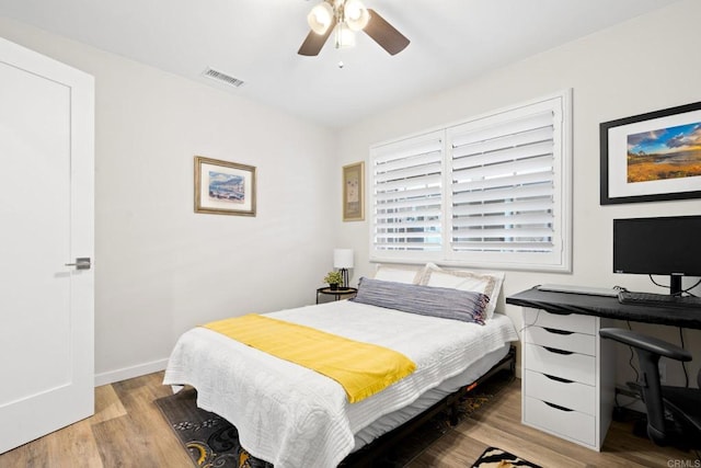 bedroom featuring baseboards, a ceiling fan, visible vents, and light wood-style flooring