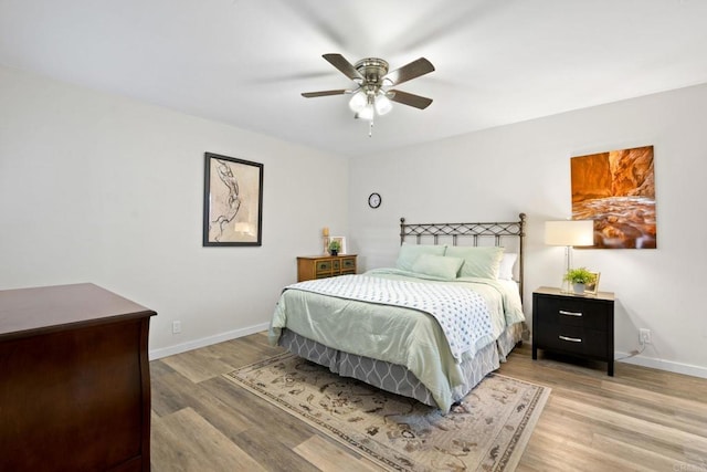 bedroom with ceiling fan, baseboards, and light wood-style floors