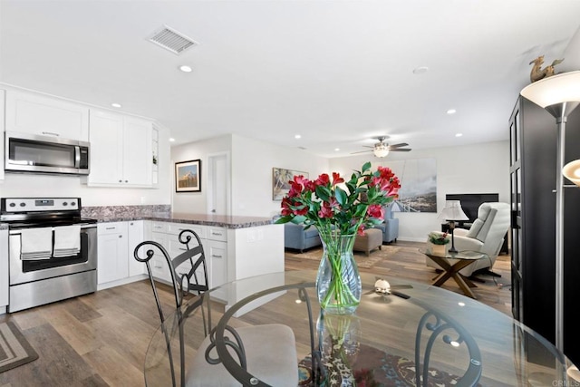 dining space with a ceiling fan, wood finished floors, visible vents, and recessed lighting
