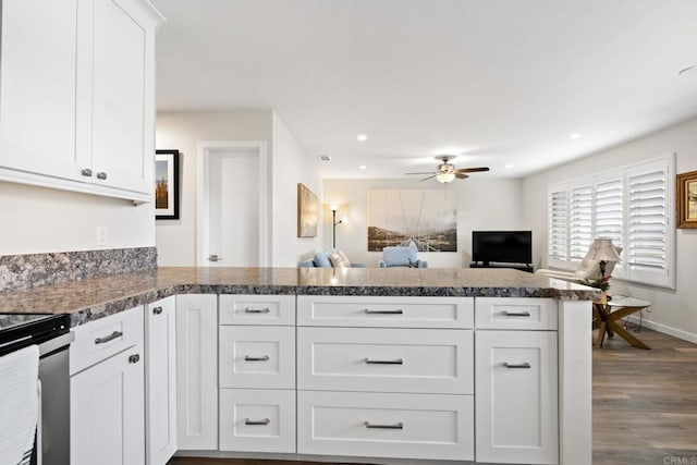 kitchen featuring white cabinets, a peninsula, electric range, a ceiling fan, and dark wood-type flooring