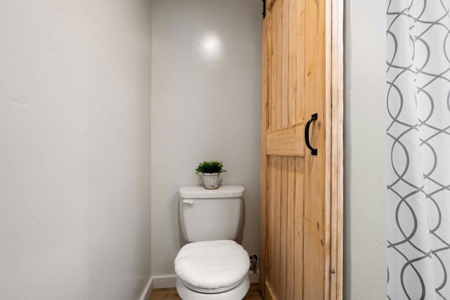 bathroom with baseboards and toilet