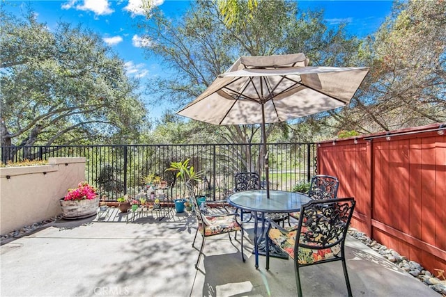 view of patio with outdoor dining area and fence