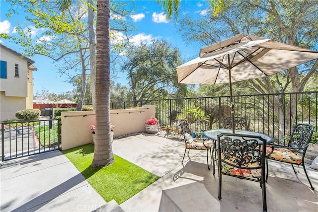 view of patio featuring outdoor dining space and fence