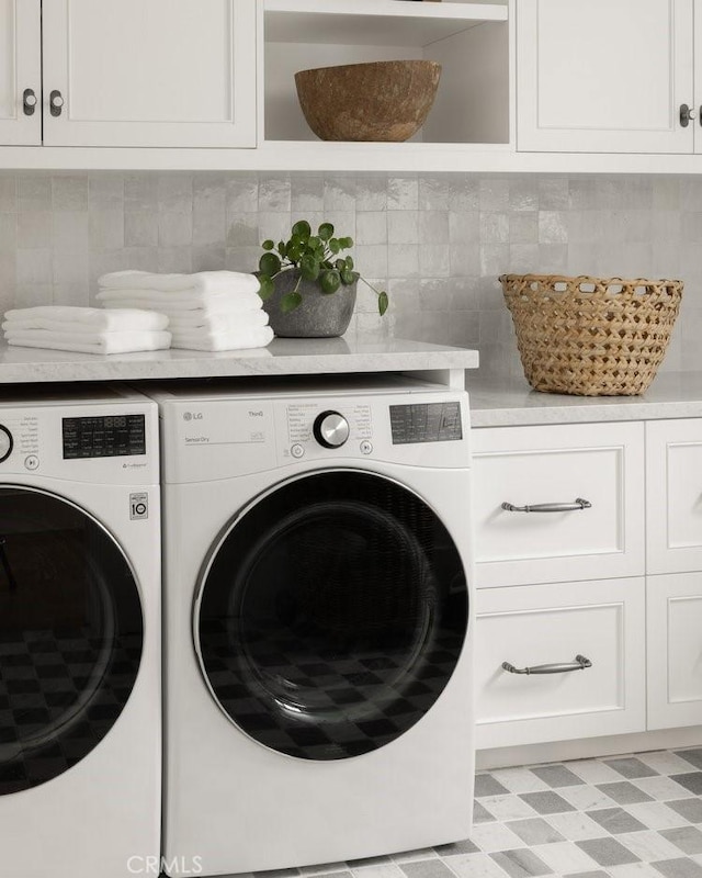 washroom featuring cabinet space, separate washer and dryer, and light floors