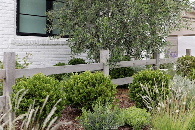 exterior space featuring brick siding and fence