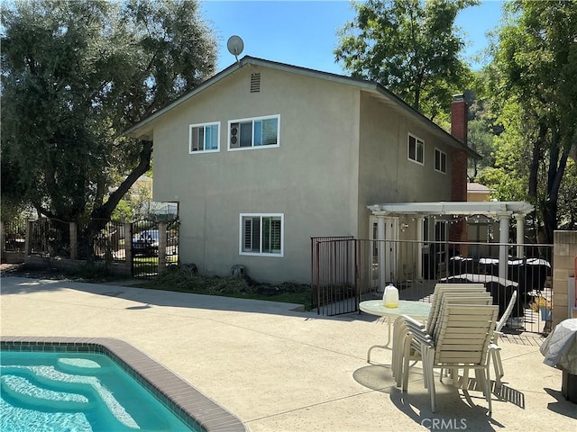 back of house featuring stucco siding, a fenced in pool, a patio, and fence