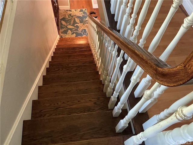 stairs featuring wood finished floors