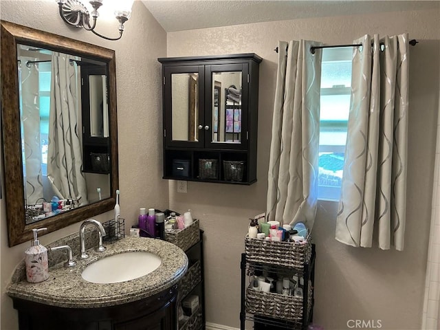 bathroom featuring vanity and a textured wall